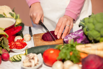 Woman cutting beetroot with a knife