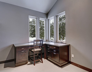 Gray and blue home office features a vaulted ceiling