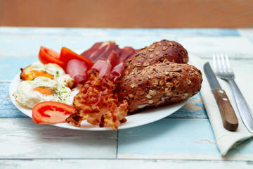 Freshly made breakfast with bacon, eggs and buns