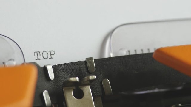 Close up footage of a person writing TOP SECRET on an old typewriter, with sound
