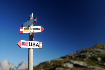 USA and German flags on signpost, politics concept