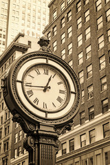 Fototapeta na wymiar Manhattan Sidewalk Clock at 5th Avenue in New York City (USA). Edited as a vintage photo with dark edges.