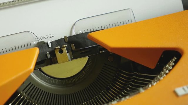 High angle footage of a person writing ABORTION on an old typewriter, with sound...
