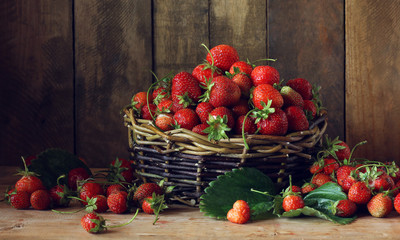 Fototapeta na wymiar Basket of strawberries on wooden background.
