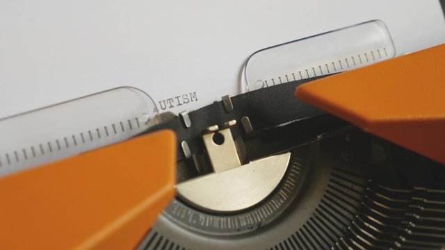 Side angle footage of a person writing AUTISM on an old typewriter, with sound...