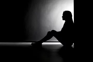 Fotobehang Silhouette einer sitzenden jungen Frau © akf