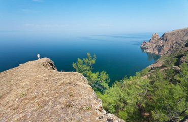 Lake Baikal. Olkhon Island. The tourist photographs Cape Khoboy on a summer day