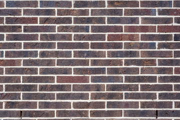 Background and texture of dark brown brick wall surface.