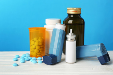 Asthma inhalers with medicines on blue background