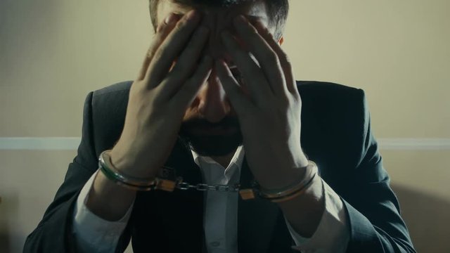 male businessman in handcuffs as a symbol of corruption