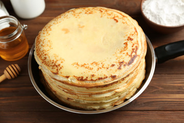 Tasty pancakes on pan on table