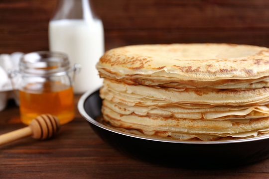 Tasty pancakes on pan on table