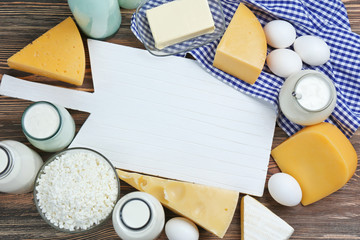 Different dairy products near cutting board, top view