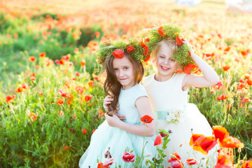 fashion, freedom, journey, travel, family, friendship concept - in the middle of poppy field there are enchanting little nymphs in gorgeous blue and white dresses and with floral wreaths on heads