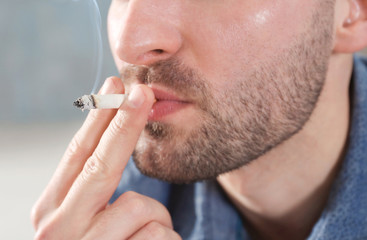 Handsome man smoking cigarette, closeup