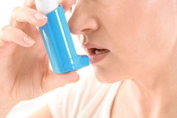 Adult woman using inhaler, closeup