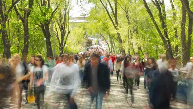 Time lapse of crowd of people walking at you with blurred images on the background of nature