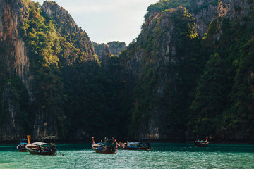Beautiful mountains at the Phi Phi islands. Touristic boats in the sea in Thailand