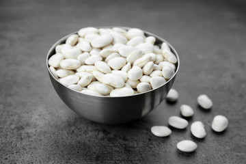 Bowl with butter beans on grey background