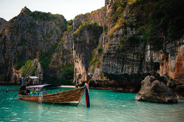 Beach with mountains and long tail boats in Phi Phi island, Thailand