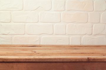 Empty wooden deck table over brick wall background