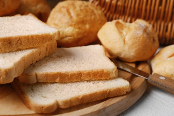 Delicious sliced bread on wooden cutting board