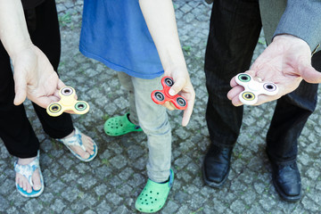 Family with multiple generations playing with fidget spinner gadgets
