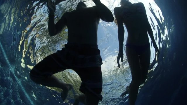 Underwater view of the young couple swimming in the pool