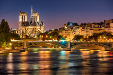 Notre Dame de Paris Cathedral, Seine River and the Sully Bridge at twilight. Summer evening on Ile...