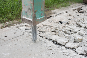 A hydraulic hammer breaks a road of paving stones