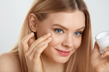 Beauty Face Care. Young Female Model Putting Cream On Eye Skin