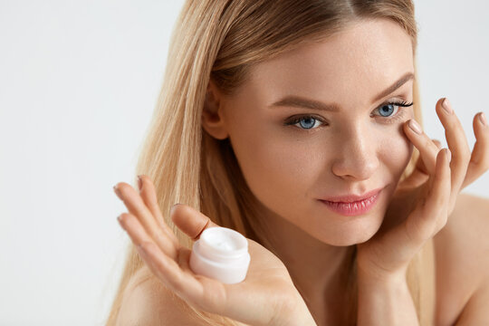 Beautiful Woman Applying Cream On Skin Under Eyes