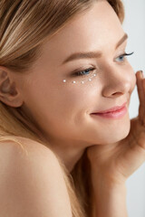 Obraz premium Facial Care. Woman With Drops Of Cosmetic Cream Under Eye