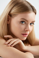 Fototapeta premium Beauty Cosmetics. Woman With Drops Of Eye Skin Cream On Skin