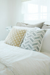 Fototapeta na wymiar Yellow and green pillow on bed in pastel interior bedroom
