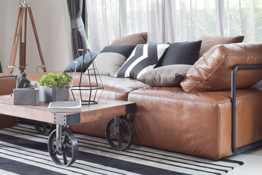 Wood center table with wheel and light brown leather sofa in industrial style decoration