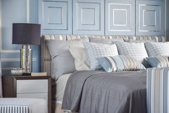 Striped an cross pattern pillows in light blue tone on classic gray bedding in classic light blue bedroom
