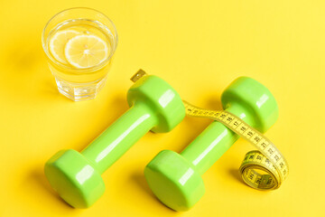 remedy for weight concept. squeezed glass of citrus, dumbbells, centimeter