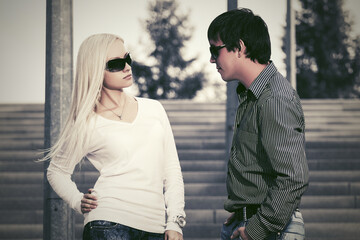 Young fashion couple in sunglasses on the steps