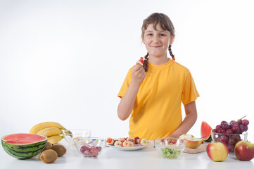 Little girl eating fruit salad - healthy food concept - isolated