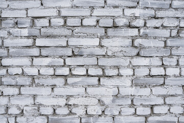 Fragment of old brick fence whitewashed by lime, relief surface and natural background