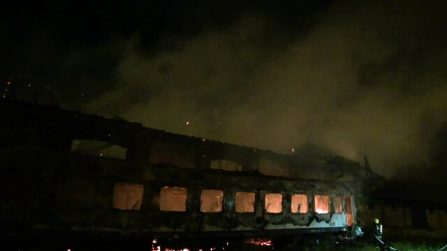 warehouse and wagon on fire at night