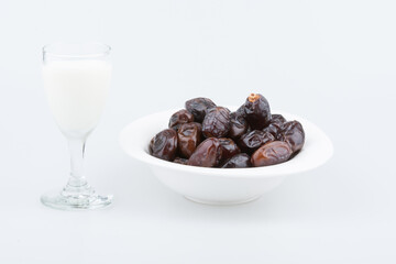 Isolated dates with milk in a plate 