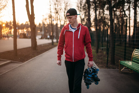 Young man with roller skates in hands
