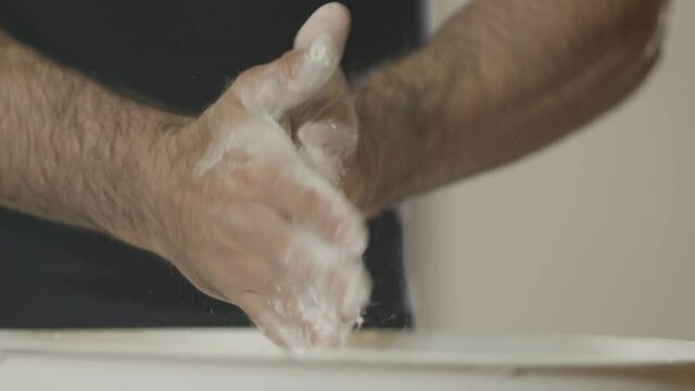  Closeup hands clapping with white chalk powder. Athlete claps  hands with talcum powder. Slow motion