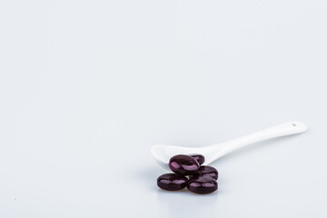 Purple pills on spoon isolated on white