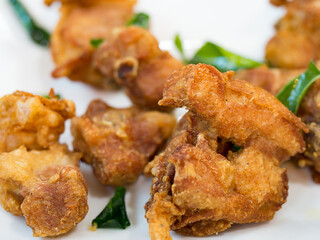 Appetizer fried chicken with crispy skin served with crunchy kaffir lime leaves add texture and fragrant that is full of Thai curry flavor.
