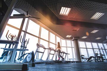 Obraz na płótnie Canvas The athletic woman running on the treadmill in the gym
