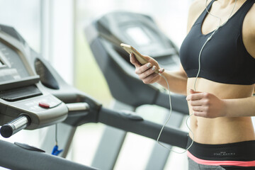 The athletic woman hold a phone in the sport club