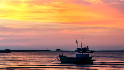 Fototapeta na wymiar small fishing boat at beach with sunset